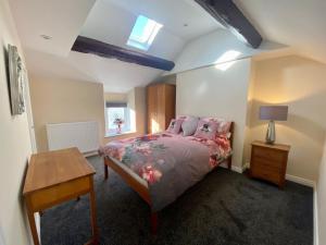 拉姆西Mountain Dream Ramsey Isle of Man的一间卧室配有一张床、一张桌子和一个窗户。