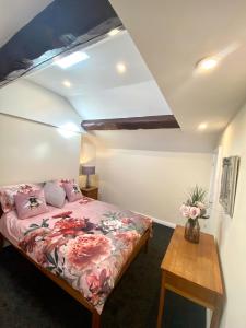 拉姆西Mountain Dream Ramsey Isle of Man的一间卧室配有一张床和一张木桌