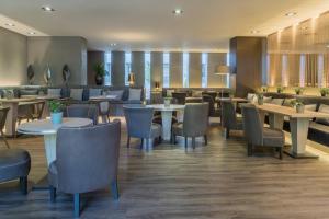 塞维利亚塞维利亚市万豪AC酒店的一间在房间内配有桌椅的餐厅