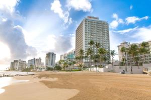 圣胡安圣胡安万豪度假及斯特拉瑞斯娱乐场酒店的拥有高耸建筑和棕榈树的海滩