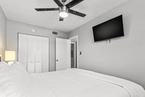 圣徒皮特海滩Sunset Beach Suites的卧室配有白色的床和平面电视。
