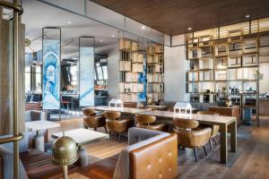门洛帕克尼亚傲途格精选酒店的一间带长桌和椅子的餐厅