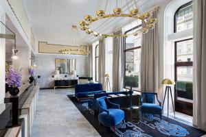 华沙华沙布里斯托尔豪华精选酒店的客厅配有蓝色椅子和吊灯。
