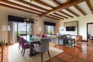 圣何塞Costa Rica Marriott Hotel Hacienda Belen的一间带桌椅的用餐室和一间客厅