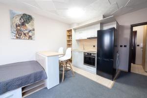 瓦尔纳Luxury Studio Apartment - Varna Residens的小房间设有床铺和黑冰箱