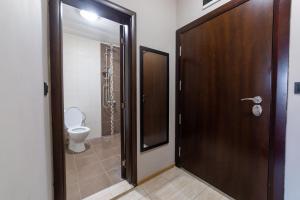 瓦尔纳Luxury Studio Apartment - Varna Residens的一间带卫生间和木门的浴室