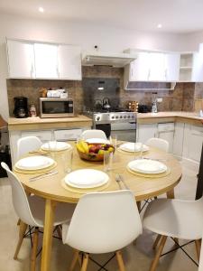 昆卡Casa Isabel的厨房配有木桌和白色橱柜。