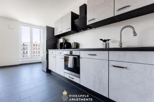 德累斯顿Pineapple Apartments Dresden Altstadt III - 91 qm - 1x free parking的厨房配有白色橱柜和炉灶烤箱。