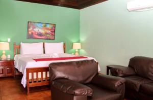 大玉米岛卡萨加拿大酒店的一间卧室配有一张沙发和椅子的床