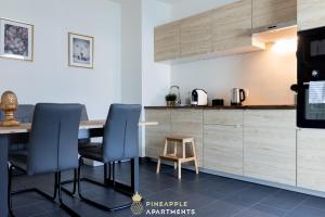 德累斯顿Pineapple Apartments Dresden Altstadt V - 112 qm - 1x free parking的厨房配有桌子、两把椅子和台面