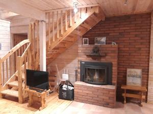 库萨莫Vihreä Helmi的一间带壁炉和楼梯的客厅
