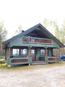 库萨莫Vihreä Helmi的小型绿色房屋设有门廊和阳台