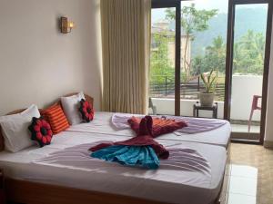 康提Kandy IVY Banks Holiday Resort的一张大床,位于带大窗户的房间里