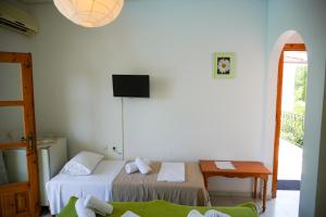 帕拉利亚潘塔利莫诺斯Irida Rooms 'n' Pool - Cozy Summer Escape的客房设有两张床、一张桌子和电视。