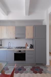 罗马Olimpico Apartment - Zen Real Estate的厨房配有白色橱柜和炉灶烤箱。