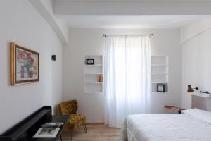 罗马Olimpico Apartment - Zen Real Estate的一间卧室配有一张床、一张书桌和一个窗户。
