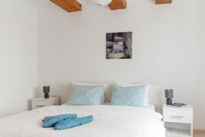 包道乔尼托毛伊Levendula Apartmanház的卧室配有白色床和蓝色枕头