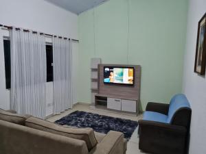 佩鲁伊比Porto Suítes Peruíbe的带沙发和电视的客厅