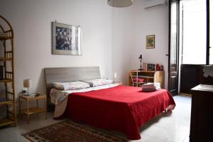 布林迪西La Terrazza sul Tempio的一间卧室配有一张带红色毯子的床