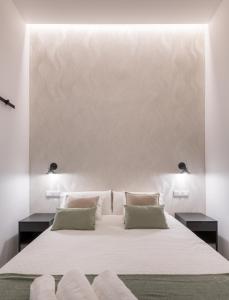马德里Loft Retiro的卧室配有一张带两个枕头的大白色床
