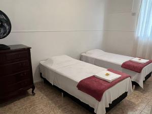 里约热内卢Apartamento Temporada Barra da Tijuca的一间设有两张床、梳妆台和梳妆台的房间