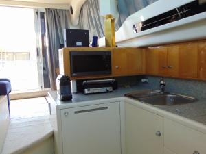 卡斯卡伊斯Payva & Branco Boats Iate privado em Cascais的一个带水槽的厨房和一台台面上的电视