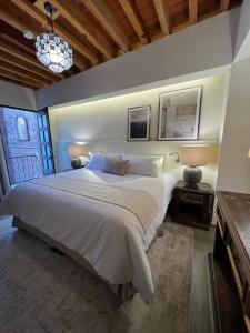 圣胡安德里奥Hotel Boutique Rincón de Luna的卧室设有一张白色大床和一扇窗户。