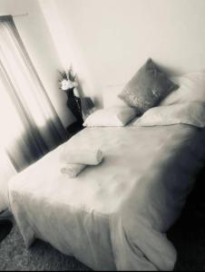 布鲁堡史特兰Zagorski’s Bed and breakfast的卧室内的一张带白色床单和枕头的床