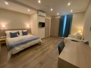 圣保罗湾城Aquae Stays的一间卧室配有一张床、一张沙发和一台电视。