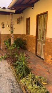 阿雷亚Casarão 47的一座房子,庭院里种有植物,门