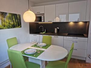 克拉尼斯卡戈拉Cosy Forest的厨房配有白色的桌子和绿色的椅子