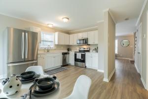 夏洛特Modern Stunning SouthPark/Cotswold Home!的厨房配有白色橱柜和桌椅