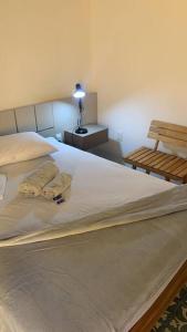 阿雷亚Casarão 47的一间卧室配有一张带台灯和长凳的床