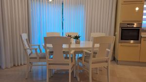 纳哈里亚אבני החושן- Avnei Hoshen的厨房配有餐桌和椅子