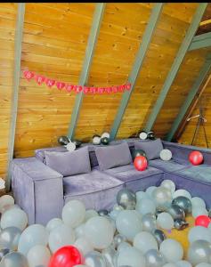 萨潘贾Özlifesapanca Bungalow的一间装满气球和紫色沙发的房间