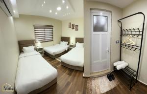 瓦迪穆萨Petra Voila的一间酒店客房,设有两张床和一扇门