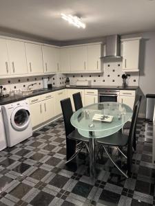 StanningleyThe Farm House Modern spacious 2 bedroom home at Tong road Leeds perfect for contractors free secure parking的厨房配有桌子和洗衣机。