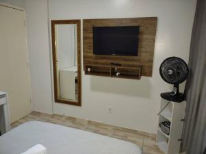 圣若泽Kitnet calma的卧室配有平面电视和风扇。