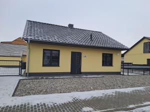 吕本Ferienhaus Spreewaldliebe的黄色的房子,有黑色的门