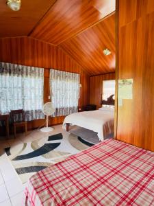 奥兰治沃克Lamanai Riverside Retreat的一间卧室设有两张床和木墙