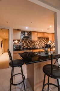格拉斯哥West End Escape - 5 Star Luxury - Prime Location的厨房配有2张吧台凳和1个柜台。