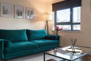 格拉斯哥West End Escape - 5 Star Luxury - Prime Location的客厅配有绿色沙发和玻璃桌