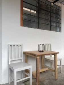 巴尼奥斯Tiny apartment in the city rooftop terrace的一张木桌和两把椅子,靠墙