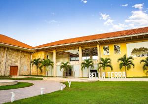 SauceBella Terra Laguna Azul Resort & Spa的一座黄色的大建筑,前面有棕榈树