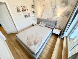 济夫努夫Apartament Superior & SPA Marina Dziwnów的一间卧室配有一张床,墙上挂有绘画作品