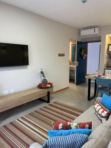 皮雷诺波利斯Eco Resort Quinta Santa Bárbara的客厅配有沙发和墙上的电视