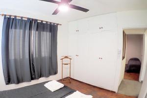 BarraqueroDepartamento Bouquet的一间卧室配有一张床和吊扇
