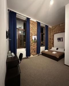 利沃夫Hotel Rover的一间卧室设有一张床和砖墙
