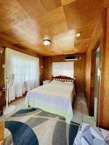 奥兰治沃克Lamanai Riverside Retreat的一间卧室设有一张带木制天花板的大床
