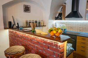 波普拉德Penzión Familia的厨房设有砖台,上面有一碗水果